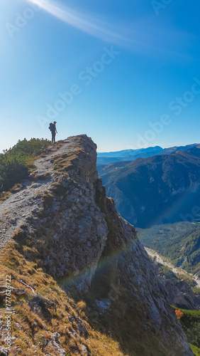 Hiker man standing on mountain summit with panoramic view of majestic Hochschwab massif  Styria  Austria. Idyllic hiking trail in remote Austrian Alps. Sense of escapism  peace  personal reflection