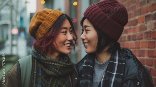 LGBTQ+, Two joyful lesbian women in winter attire sharing a close and intimate moment on a city street, embodying friendship and happiness.
