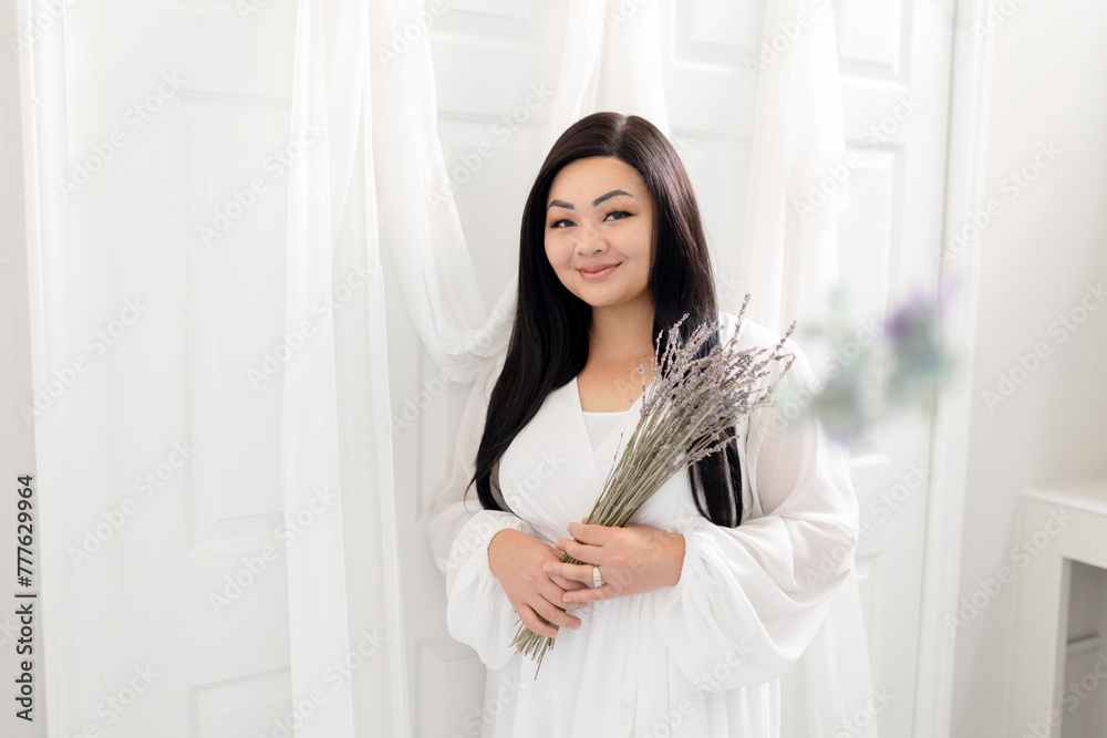 Asian woman in serene environment, all white, holding dead flowe Asian woman in serene environment, all white, holding dead flowe