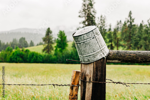 Upside down tin bucket on wood fence in Montana countryside