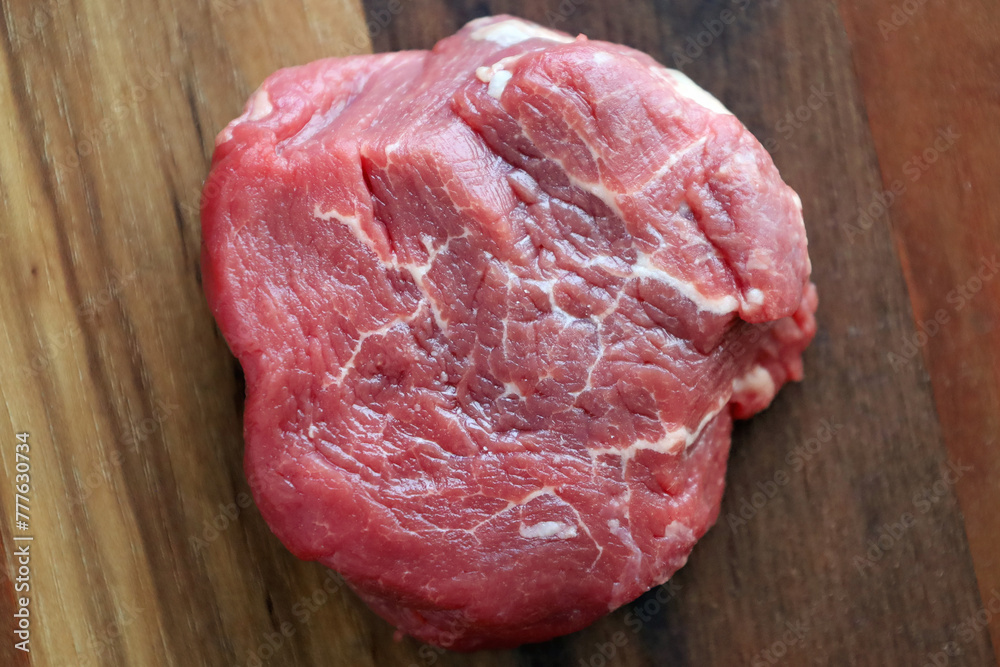 Prime filet mignon on a wooden board, ready for seasoning
