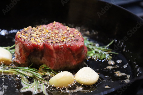 Canvas Print Seasoned raw filet mignon searing in cast iron skillet