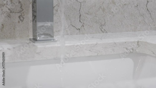 Water pouring from a fresh faucet - remodeled bathroom. photo