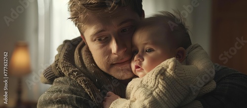 A man tenderly holds a baby in his arms, showcasing a heartwarming moment of paternal care.