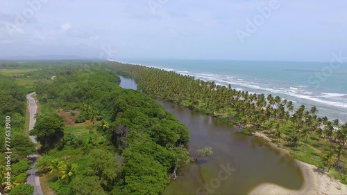 Nariva River, Manzanilla Mayaro Road, Trinidad and Tobago. Aerial drone push-in to Caribbean sea. Sunny day palm tree coast photo