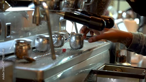 Pro Barista machine brewing fresh espresso for customer in downtown cafe photo