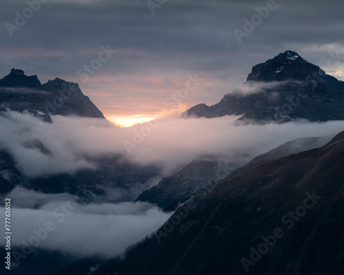 Dramatic sunset over mountains shrouded in clouds