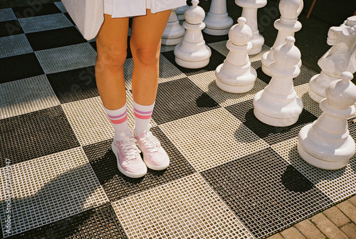 Woman standing on the square of giant  chess board  photo