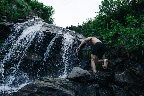 Man climbs to waterfall.
 photo