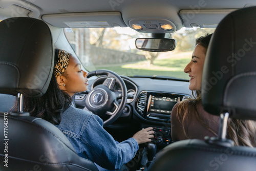 happy young woman and her friend in car 