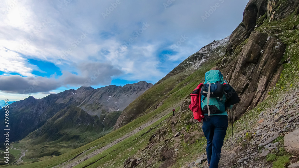 Hiker woman with scenic view of majestic mountain peaks of High Tauern near Feldseekopf, Carinthia Salzburg, Austria. Idyllic hiking trail in Goldberg group in wild remote Austrian Alps. Wanderlust
