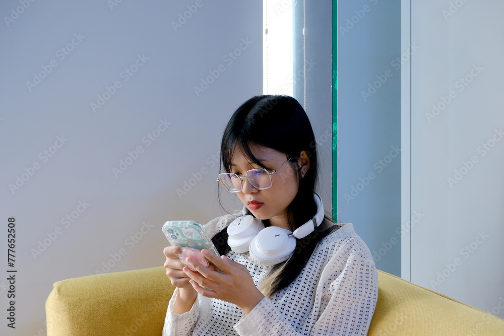 Bored Female Office Worker Looking At Cell Phone Bored Female Office Worker Looking At Cell Phone