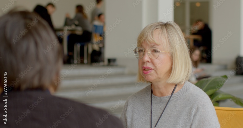 Middle adult woman is using a common gesture known as finger counting to visually represent numerical concepts. The woman is explaining while bending her fingers, counting. Middle adult woman is using a common gesture known as finger counting to visually represent numerical concepts. The woman is explaining while bending her fingers, counting.