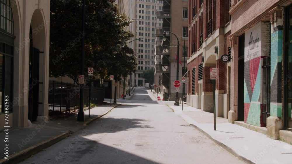 Empty street with buildings, tree, road signs and street bulb on a sunny day in Atlanta, Georgia