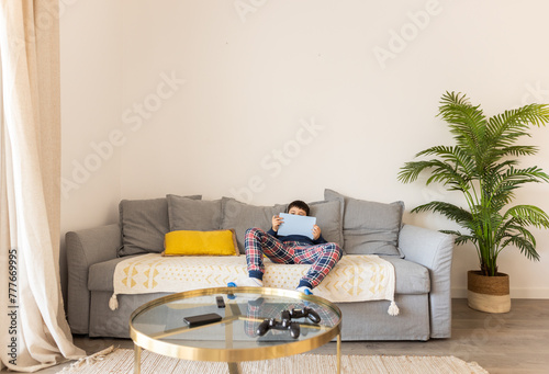 a boy in sleepwear lying on the sofa at home photo
