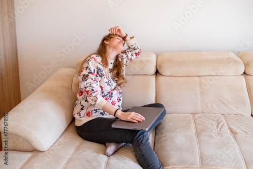 Woman sitting with closed laptop after work photo