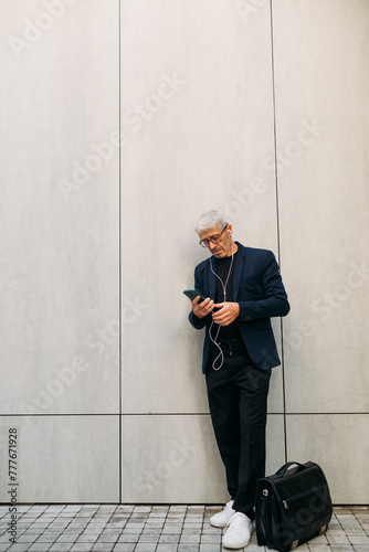 Senior man using cell phone outside photo