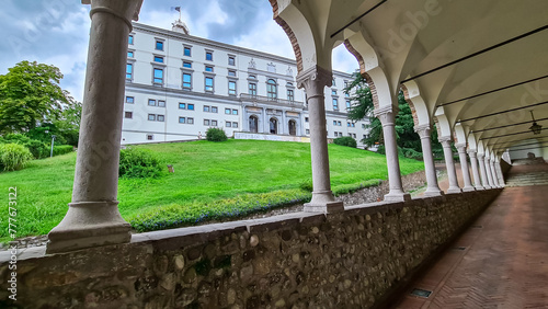 Scenic pedestrian path along renaissance Venetian gothic style arcade leading to castle of Udine, Friuli Venezia Giulia, Italy, Europe. Italian architecture columns and arches. Travel destination photo