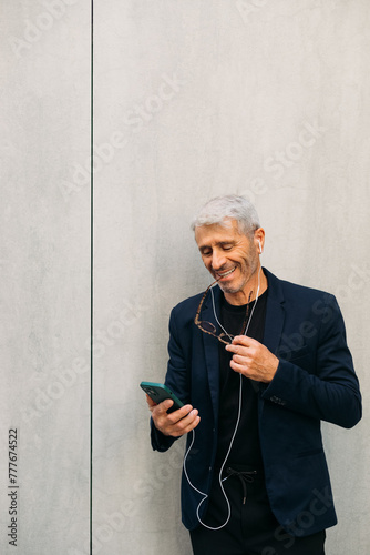 Senior man using cell phone outside photo