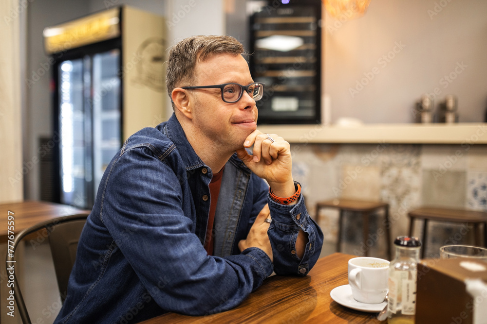 portrait of young man with down syndrome in a cafeteria portrait of young man with down syndrome in a cafeteria