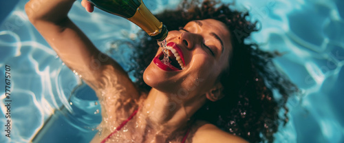 Lifestyle portrait of attractive black woman in a pool pouring champagne into her mouth directly from the bottle, celebrating on a hot summer holiday
