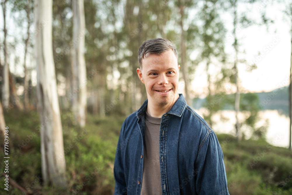 portrait of young man with down syndrome in nature portrait of young man with down syndrome in nature