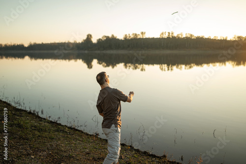 man with down syndrome next to a river in nature photo