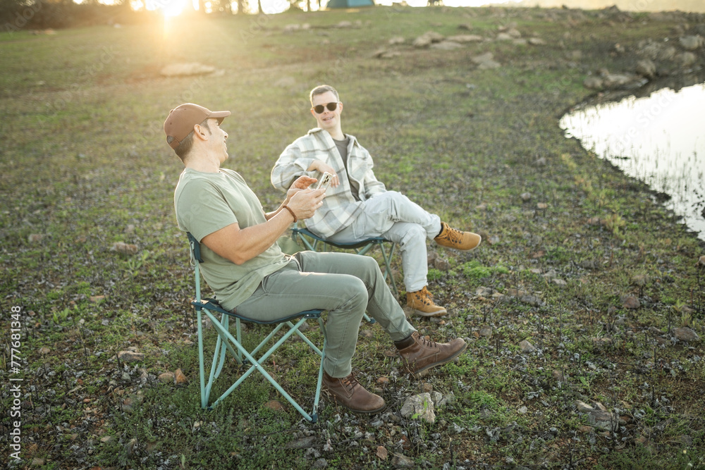 man with down syndrome with his friend laughing together in nature man with down syndrome with his friend laughing together in nature