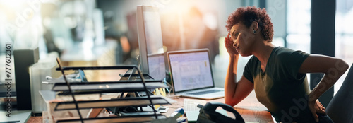 Business woman, stress and back pain on computer for human resources report, confused or fatigue in office. African worker with headache and overworked on desktop for payroll mistake on a banner photo