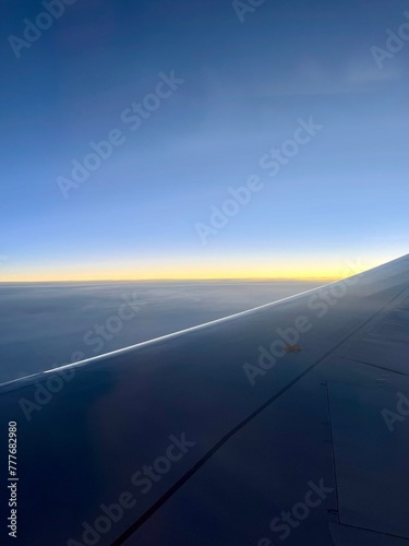 view from the airplane window, sunrise time, tender colors of the sky  © Oksana