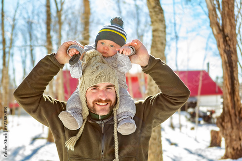 father and baby close to a maple shack having fun together