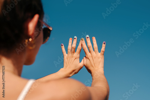 Woman showing her colorful nails and hand manicure photo