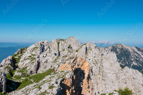 Scenic view of majestic mountain peak Hochstuhl (Stol) in untamed Karawanks, border Slovenia Austria. Looking from Vertatscha peak. Hiking wanderlust in wilderness of Slovenian Alps in summer photo