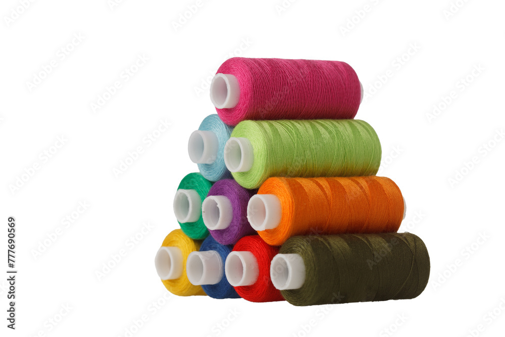 multi-colored spools of sewing thread in the form of a pyramid on a white background close-up multi-colored spools of sewing thread in the form of a pyramid on a white background close-up