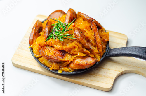 Traditional Polish dish called bigos made of sauerkraut, sausage and mushrooms, food served warm in a cast iron pan
