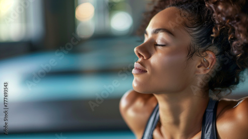 Young sportswoman in cobra pose stretching with eyes closed in health club.