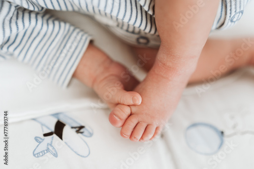 Cute baby foot and hand. Baby grabs his own foot. photo