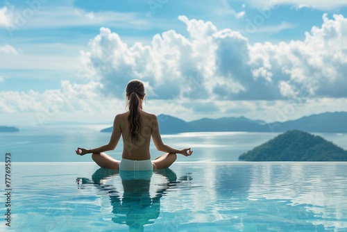 Woman meditating by an infinity pool with a panoramic view of the sea.