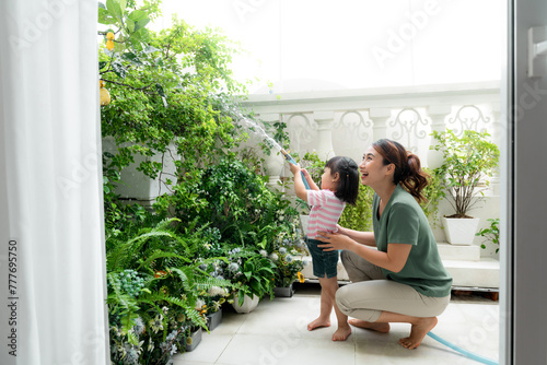 Mom and daughter helping to care for plants and flowers at home photo