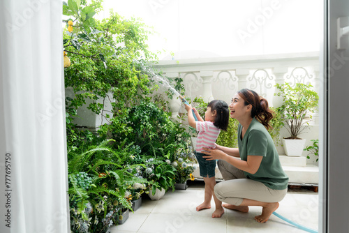 Mom and daughter helping to care for plants and flowers at home