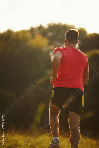 Rearview, man and running for exercise, fitness goals and workout for body health and physical training outdoor. Male runner or athlete and jog for cardio, strength or recreation on trail outside