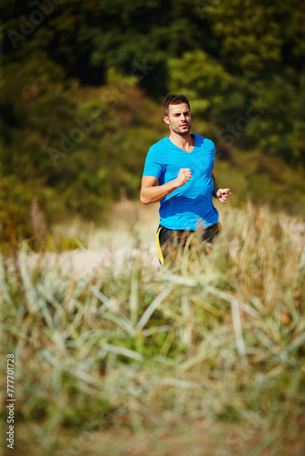 Sporty, man and running in nature for fitness, health and wellness in outdoor for workout or exercise. Male person, training and cardio with endurance, muscles and strength for healthy living or gym