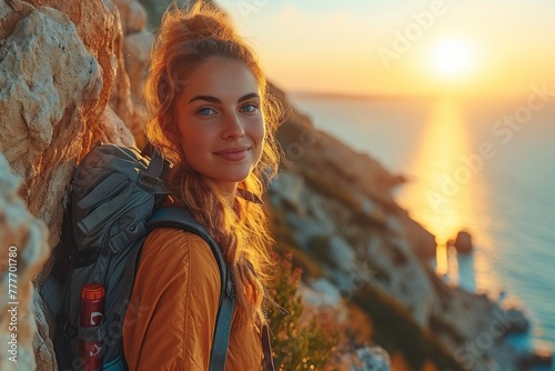 Woman backpacker stands atop mountain photo