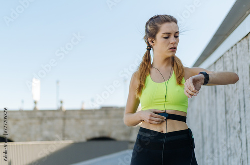 fit happy woman using a pulsometer running outdoor photo