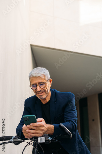 Senior man using smartphone outside photo