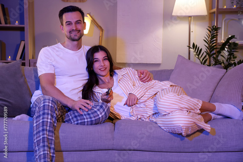 Young couple watching TV at...