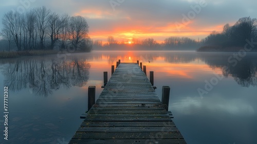  A wooden dock floating on a serene lake beneath a cloudy sky and basking in the golden light of the descending sun
