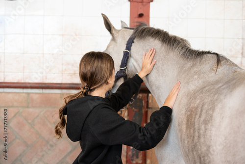 teen girl caressing  horse in therapeutic horsemanship class photo