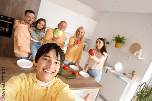 Little boy taking selfie with his family in kitchen  closeup