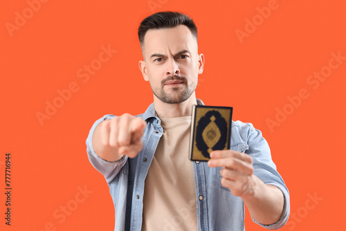 Young man with Koran pointi...